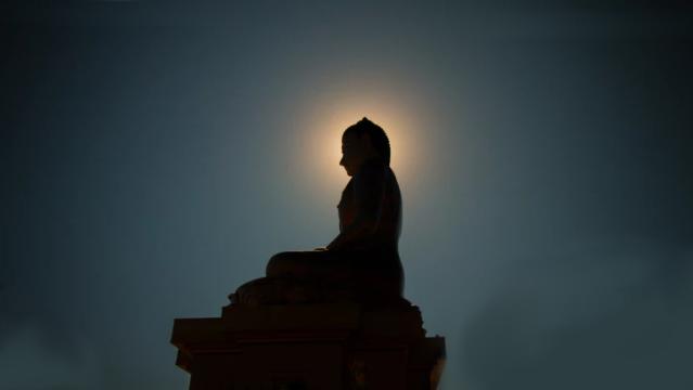 Buddha meditating statue at night