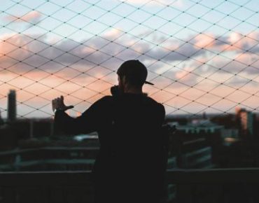 Guy standing near fence