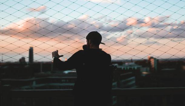 Guy standing near fence